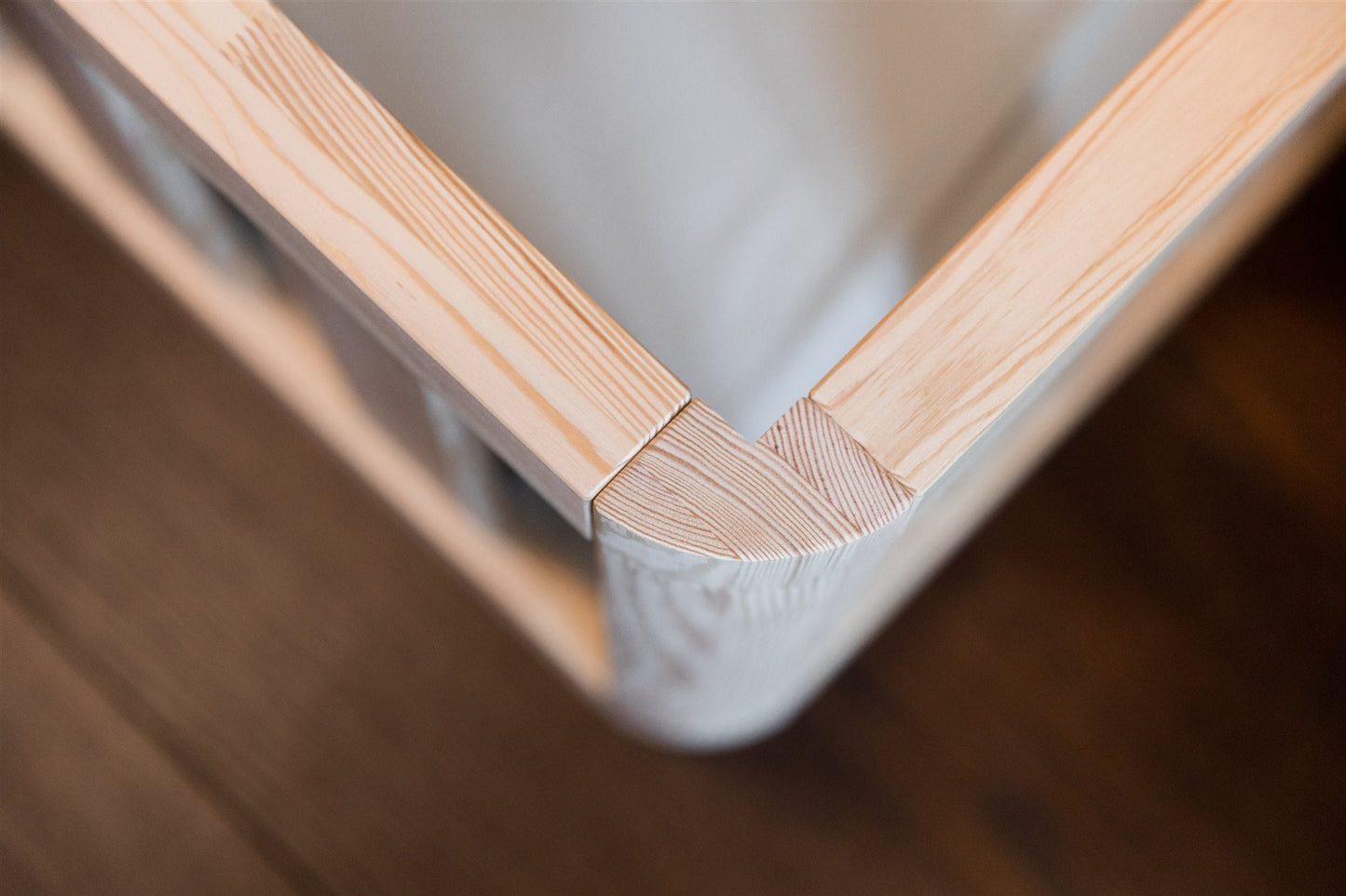 Wooden toddler floor beds rounded outer corner. In close up.