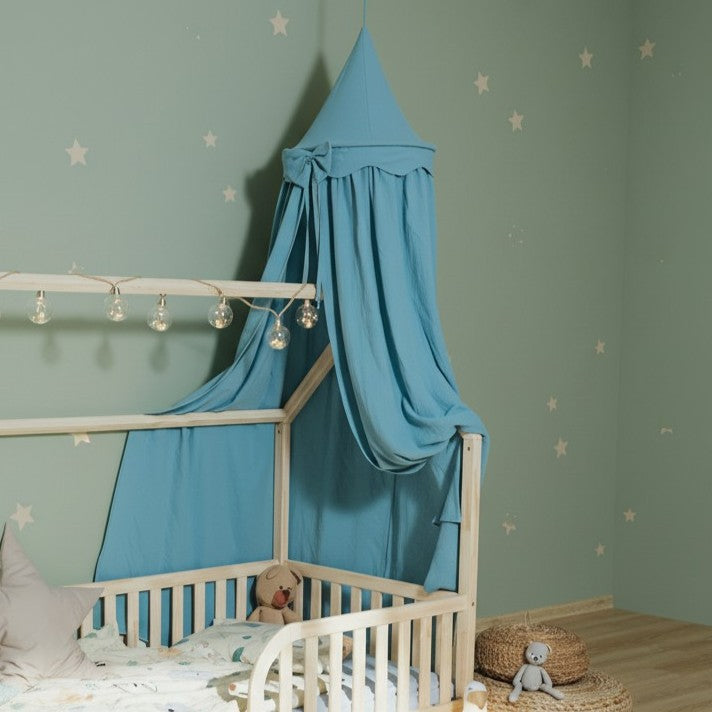 Bed canopy in blue color over the Montessori house floor bed