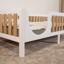 EZRA Montessori toddler bed on legs with white frame, oak veneer rails and rounded entrance