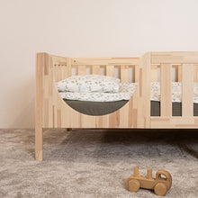 Close-up of the rounded entrance and wooden leg on the EZRA Montessori toddler bed in natural pine