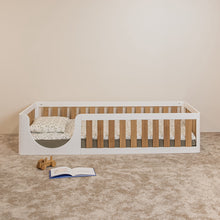 Front view of EZRA Montessori toddler floor bed with white pine frame, oak veneer rails and rounded entrance