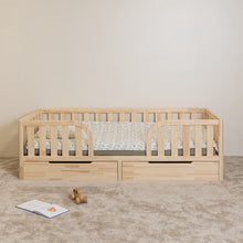 Front view of Montessori toddler bed with rounded middle opening and two closed storage drawers