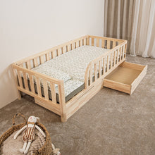 Elevated view of Montessori toddler bed with rounded opening and open storage drawer