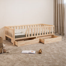 Montessori toddler bed with rounded opening and two open under-bed storage drawers