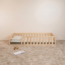 Front view of Montessori toddler floor bed with rounded opening and natural wood safety rails