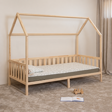 Angled view of Montessori toddler house bed on legs with open front side