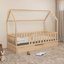 Angled view of Montessori toddler house bed with rounded entrance and closed trundle