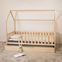 Montessori toddler house bed with trundle bed partially pulled out beneath the main bed