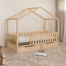 Angled view of NOLRI Montessori toddler house bed with rounded opening and two closed storage drawers