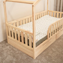 Side detail of NOLRI Montessori toddler house bed with natural pine safety rails and under-bed storage